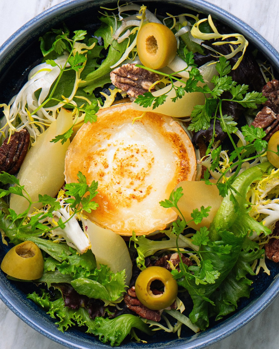 Crisp greens, pecans, olives, pear & gratinéed goat cheese. A ROOF salad worth savoring 🥗